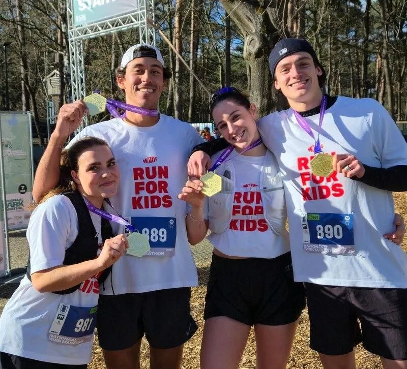 Gerardo en drie vrienden in Run for Kids shirts met hun medailles