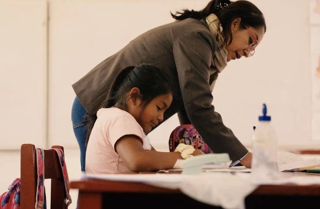 Una docente ayuda a una alumna con su trabajo en clase en Cañete
