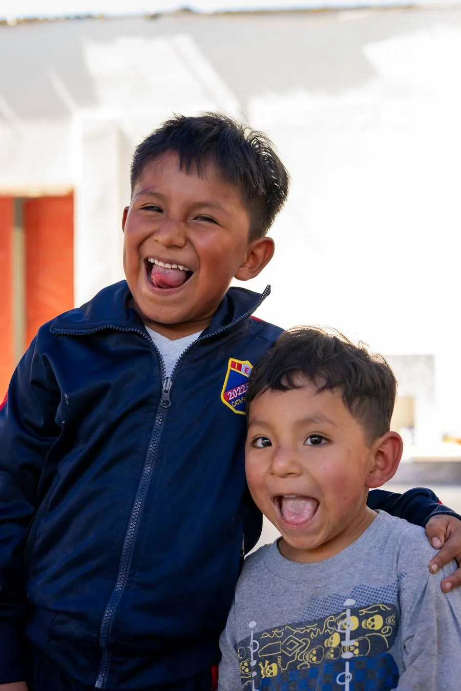 Twee jongens lachen breed naar de camera