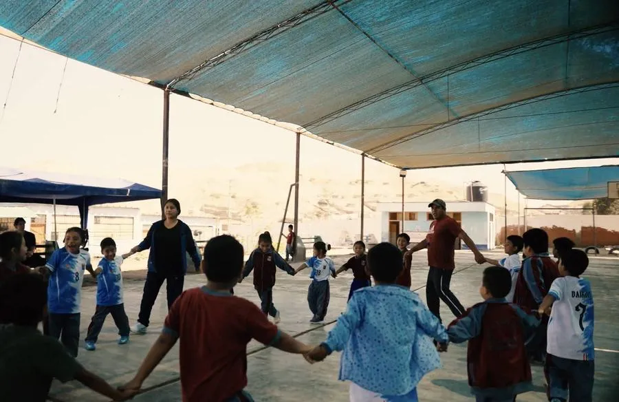 Children playing hand in hand under the canopy in the schoolyard