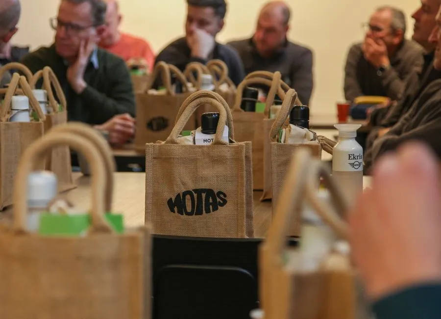 Jute MOTAS tote bags on a table during a meeting with a partner