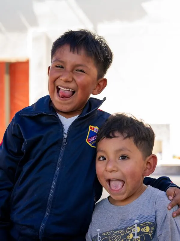 Twee jongens lachen breed naar de camera