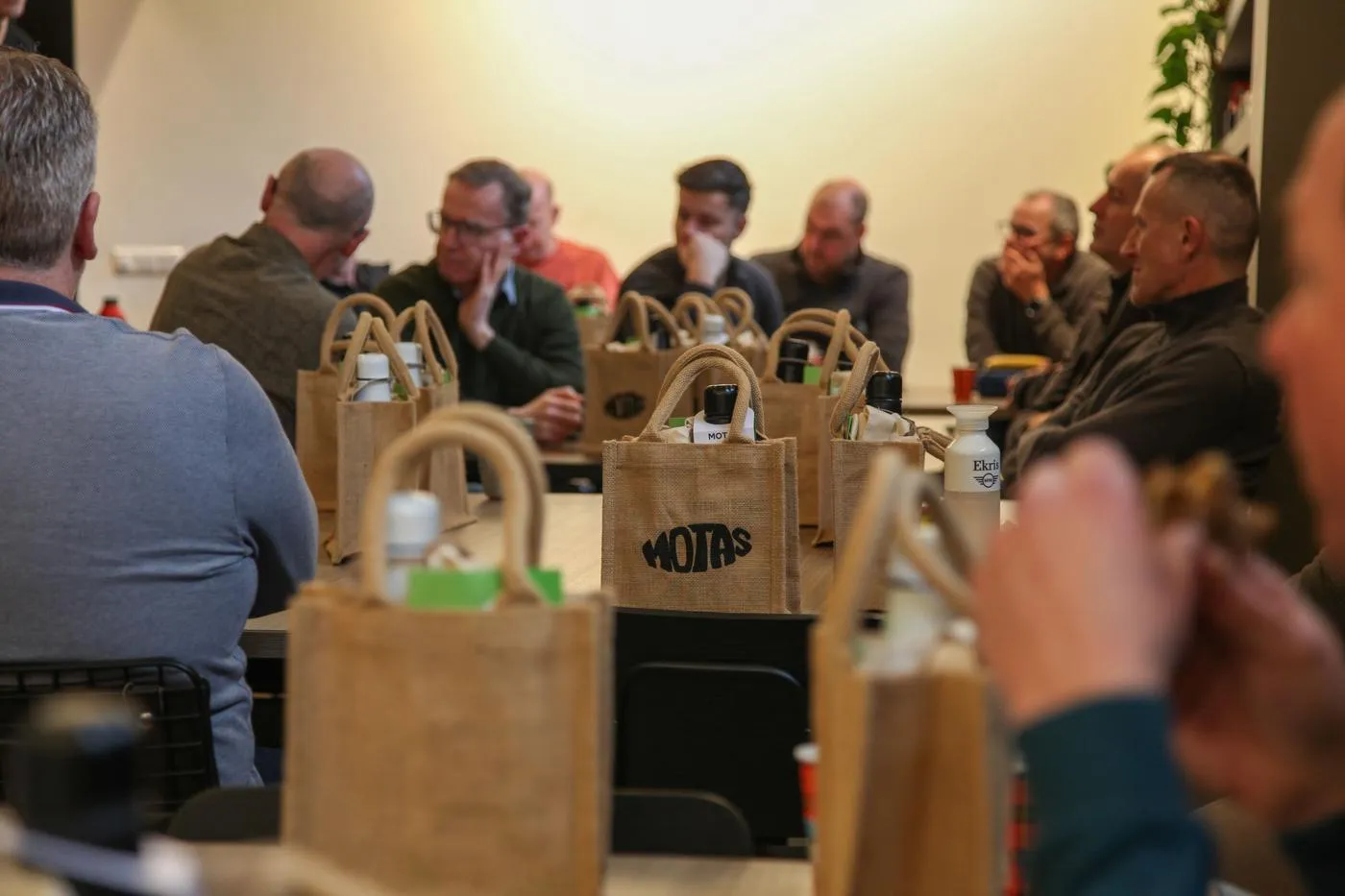 Bolsas de yute de MOTAS con regalos sobre una mesa durante una reunión en Hekker