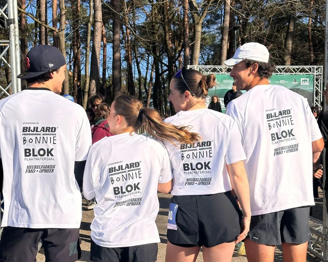 Vier lopers van Run for Kids met de logo’s van de impactpartners op hun shirts
